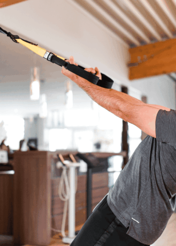 Un membre de la communauté Kineo suivant un cours de suspension training avec TRX