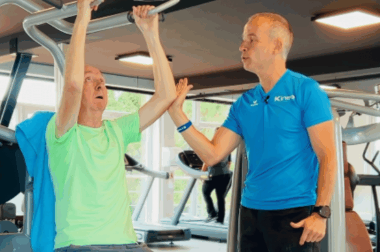 Un coach Kineo accompagne un membre sur un exercice de renforcement après une rééducation